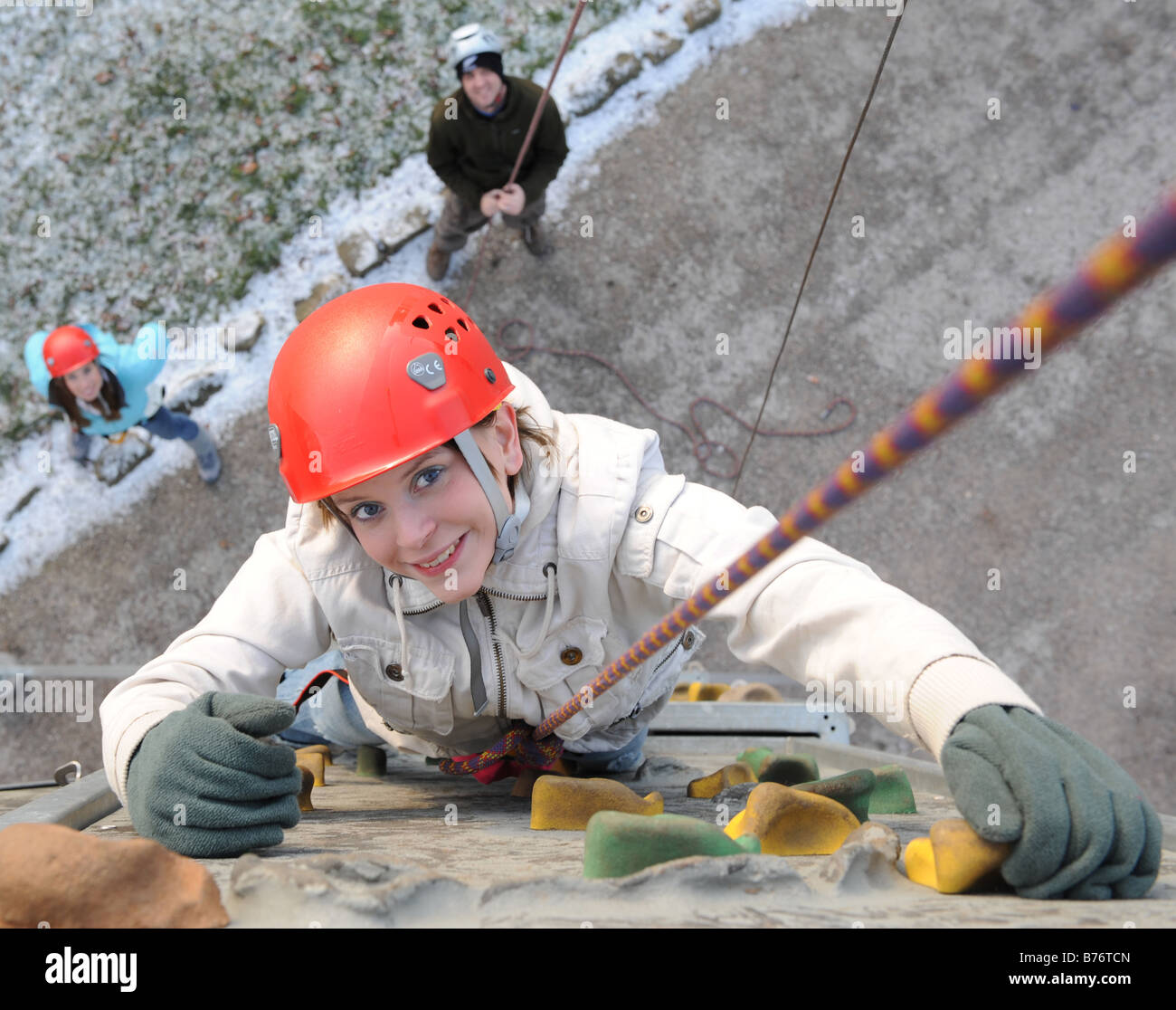 Una femmina di rocciatore salendo su un artificiale di arrampicata. Foto Stock