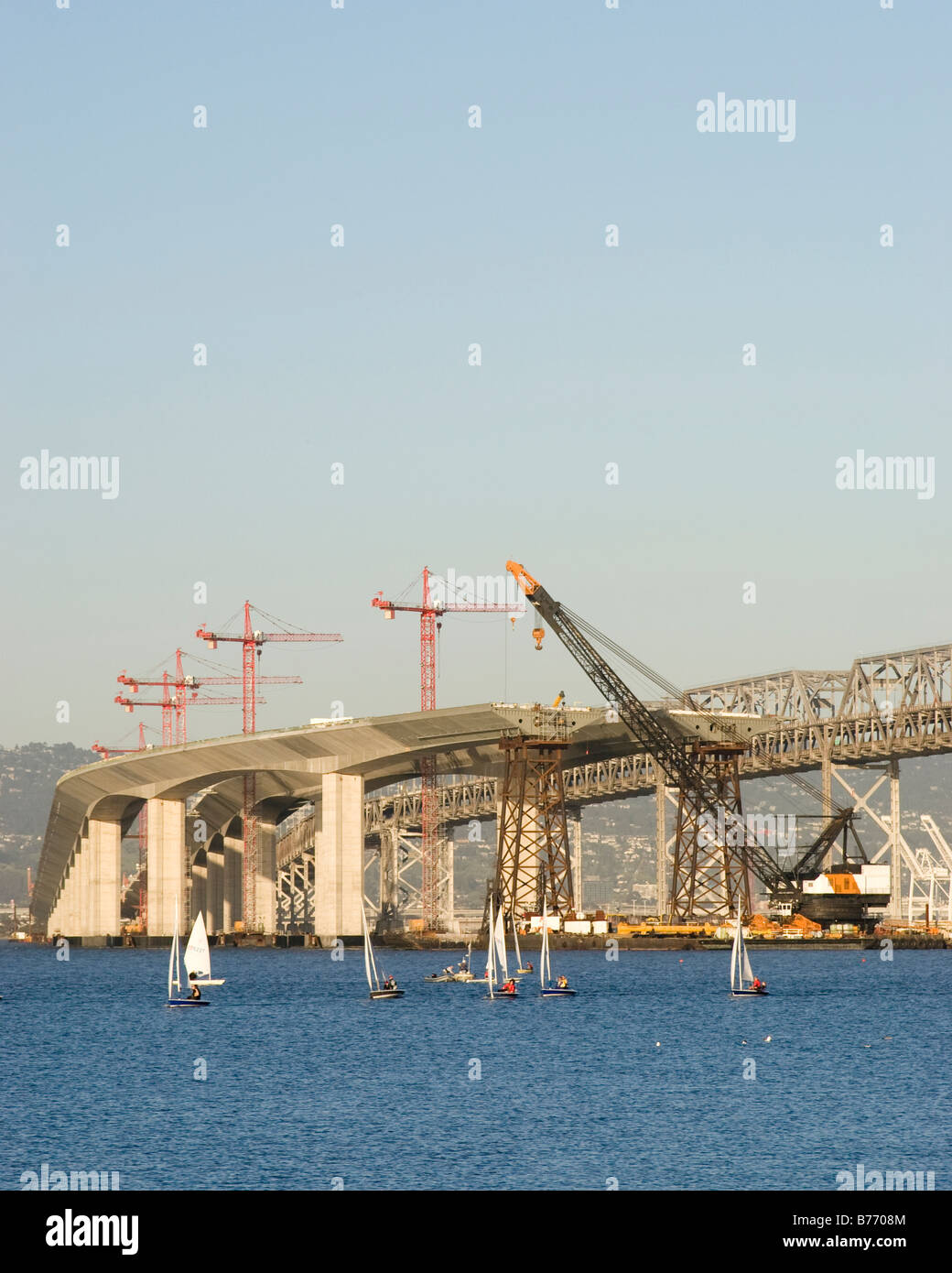 Regata di barche a vela in mezzo alla costruzione del nuovo Oakland Alameda Bay Bridge. Foto Stock