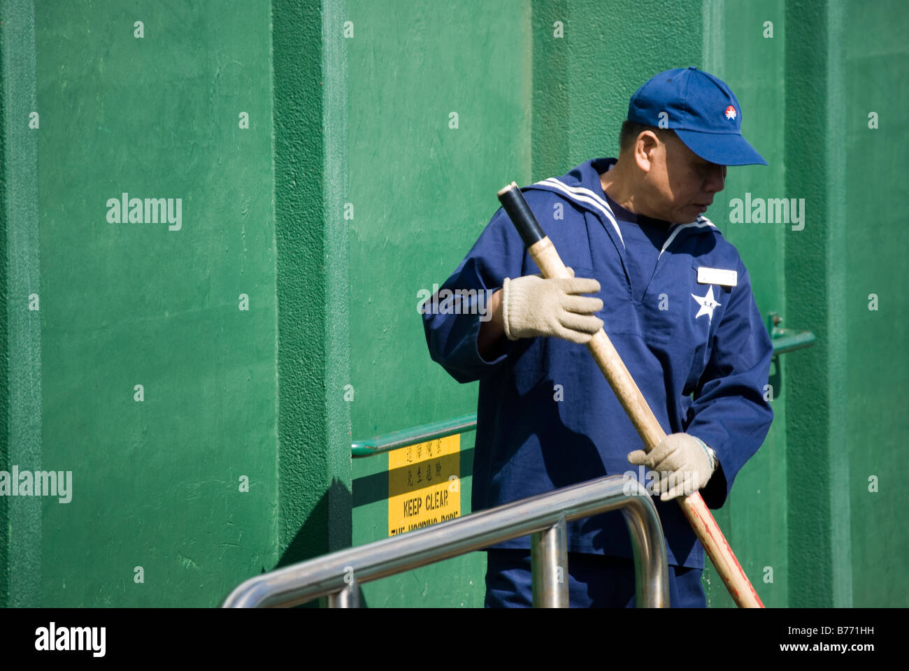 Il Traghetto Star uomo in uniforme contribuendo alla banchina del traghetto, Tsim Sha Tsui, la Penisola di Kowloon, Hong Kong, Repubblica Popolare di Cina Foto Stock