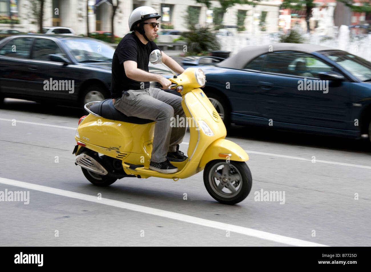 Un uomo su uno scooter giallo nel traffico, Chicago, Stati Uniti d'America Foto Stock
