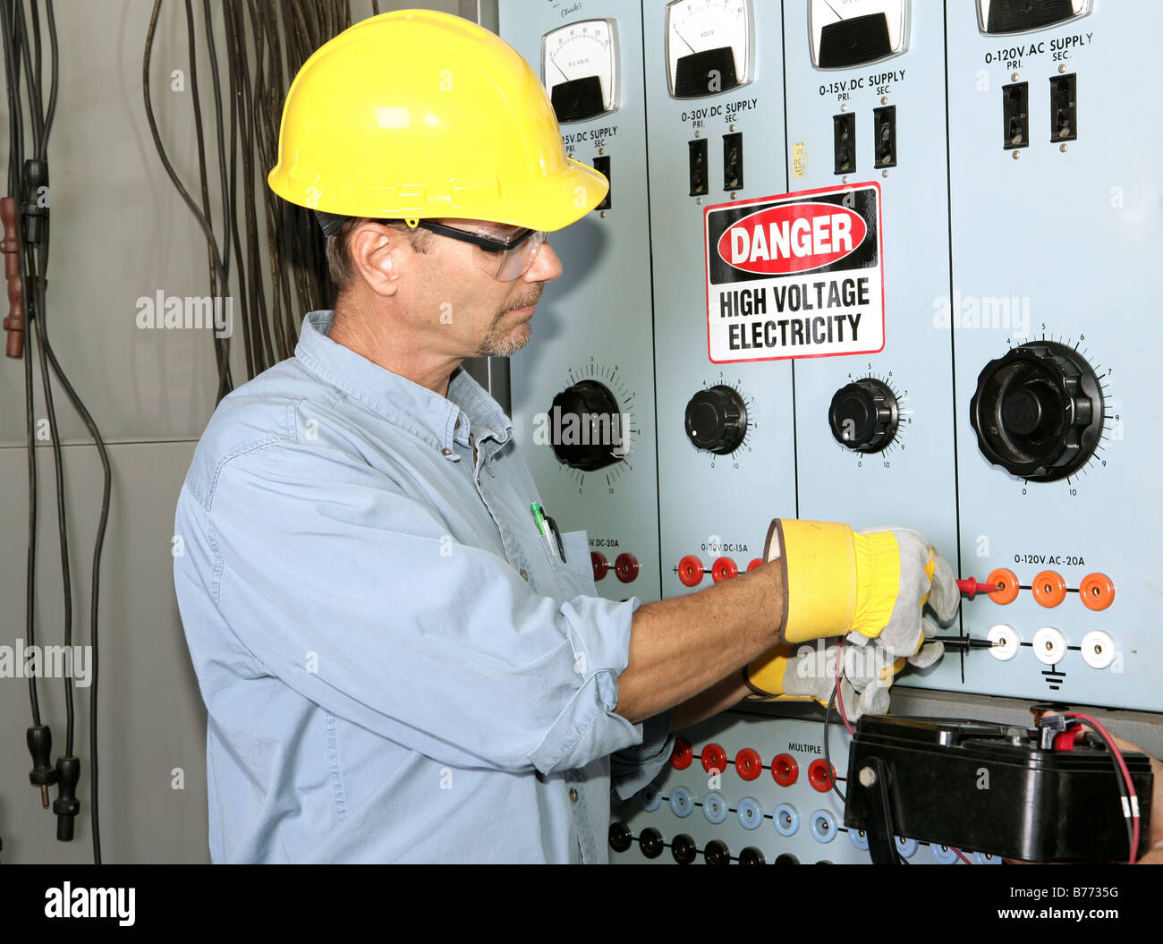 Elettricista tecnico al lavoro con il tester misura la tensione di un  sistema residenziale. Orientamento verticale Foto stock - Alamy