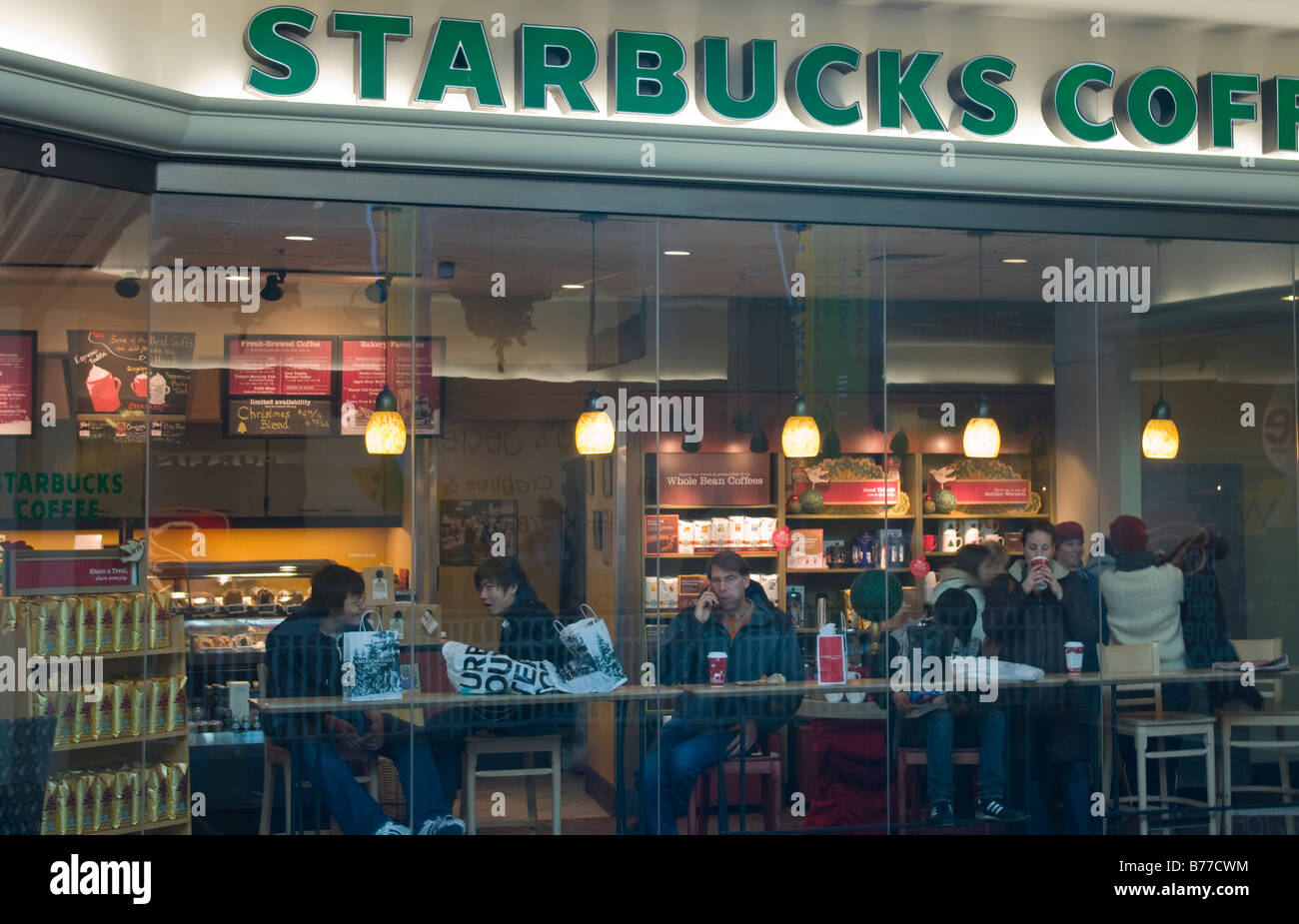 Starbucks Coffee shop all'interno di un centro commerciale per lo shopping fotografato attraverso la finestra con il segno prominente nella parte superiore Foto Stock