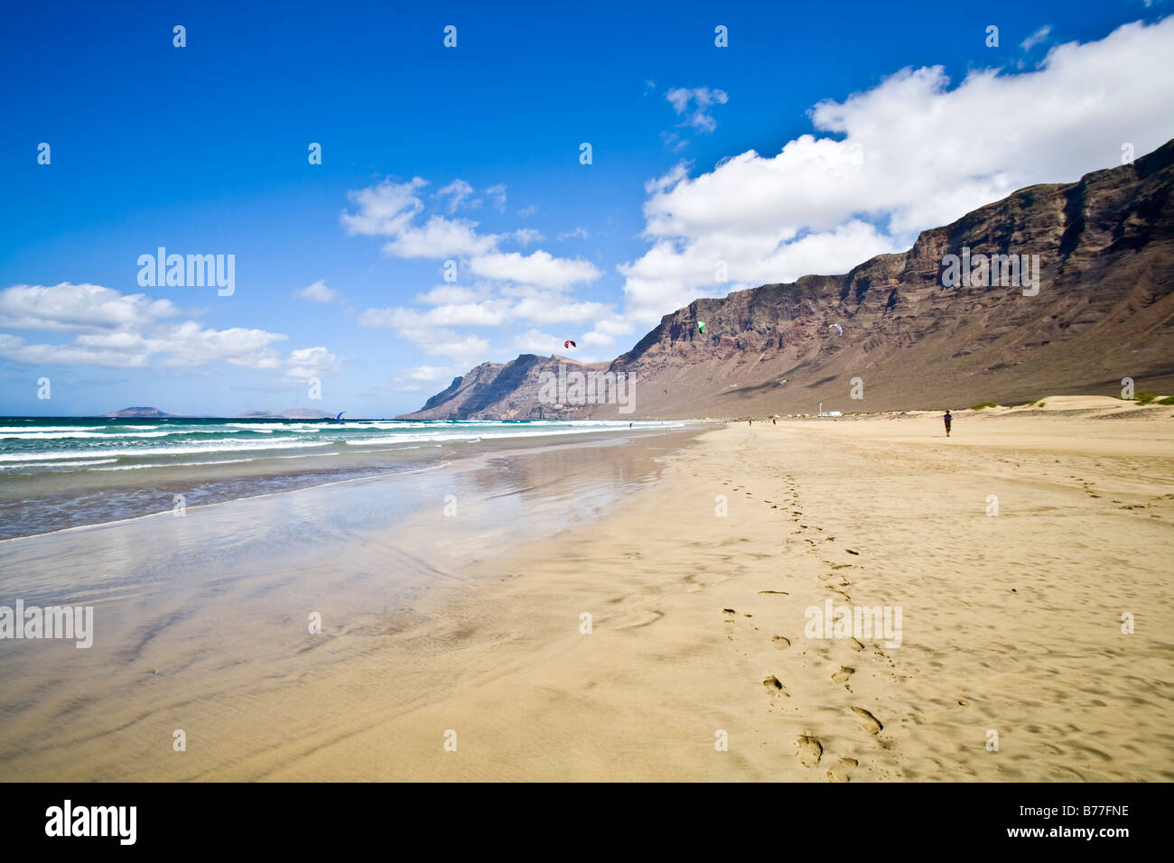 Playa de Famara risco de Famara spiaggia di sabbia di montagna rocce riflessione Lanzarote isole Canarie Spagna Foto Stock