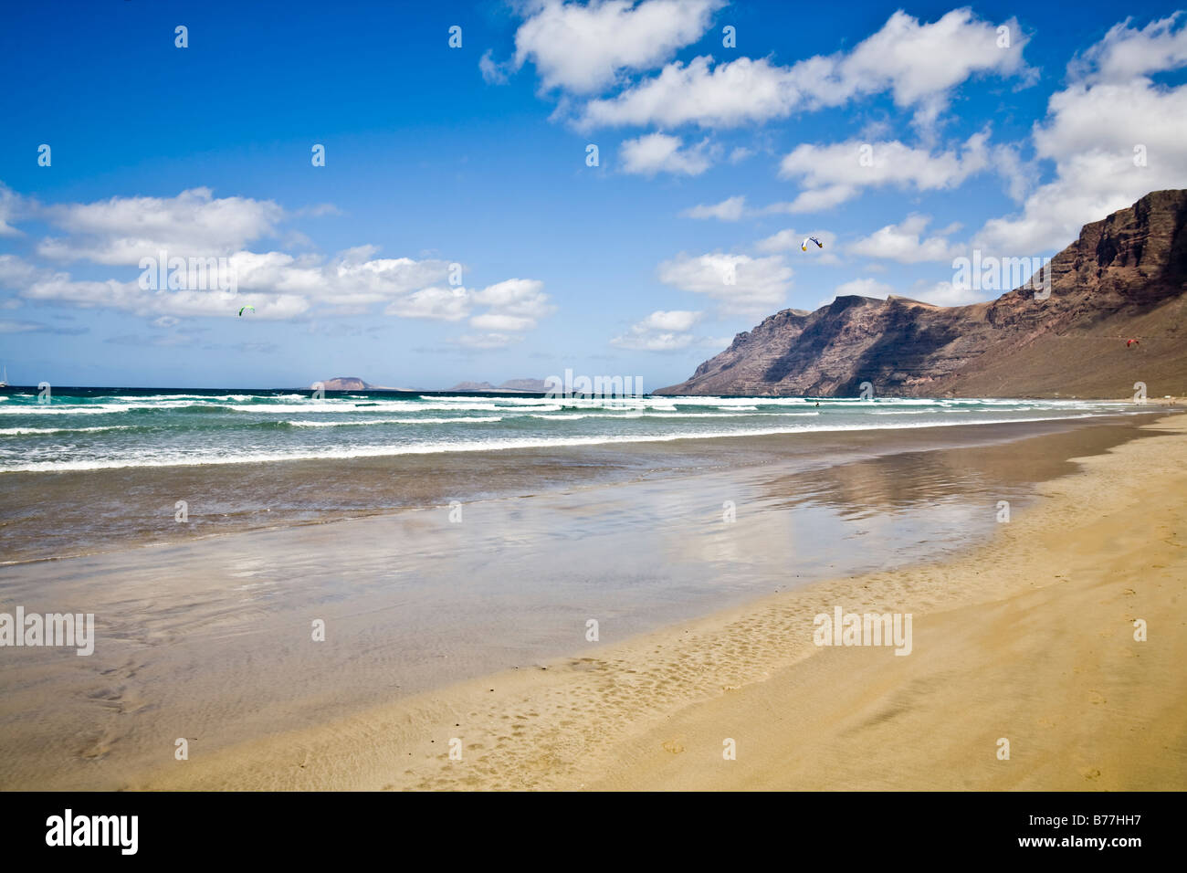 Playa de Famara risco de Famara spiaggia di sabbia di montagna rocce riflessione Lanzarote isole Canarie Spagna Foto Stock