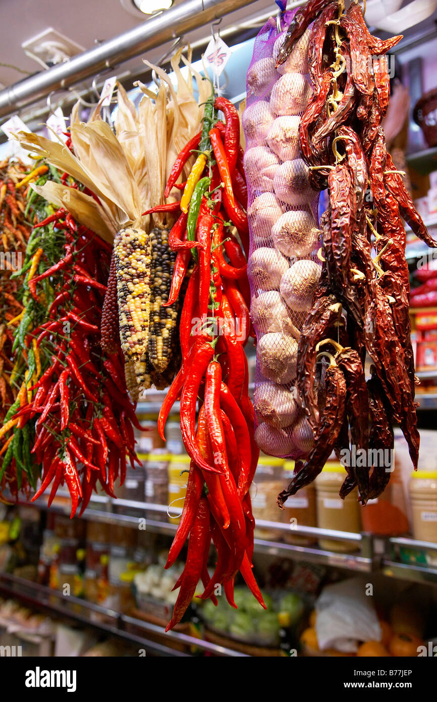 Peperoncini essiccati e aglio appeso su uno stallo presso il mercato coperto appena fuori La Rambla high street a Barcellona. Foto Stock