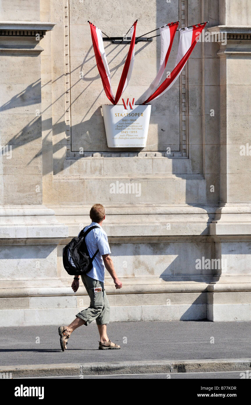 Per turisti in cerca di una targa commemorativa come egli cammina oltre la Staatsoper, Opera di Stato di Vienna, Austria, Europa Foto Stock