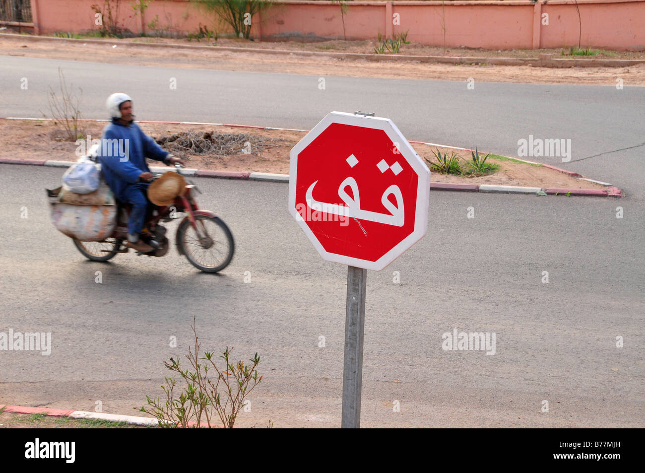 L'uomo su un ciclomotore, segno di stop in arabo, Marrakech, Marocco, Africa Foto Stock