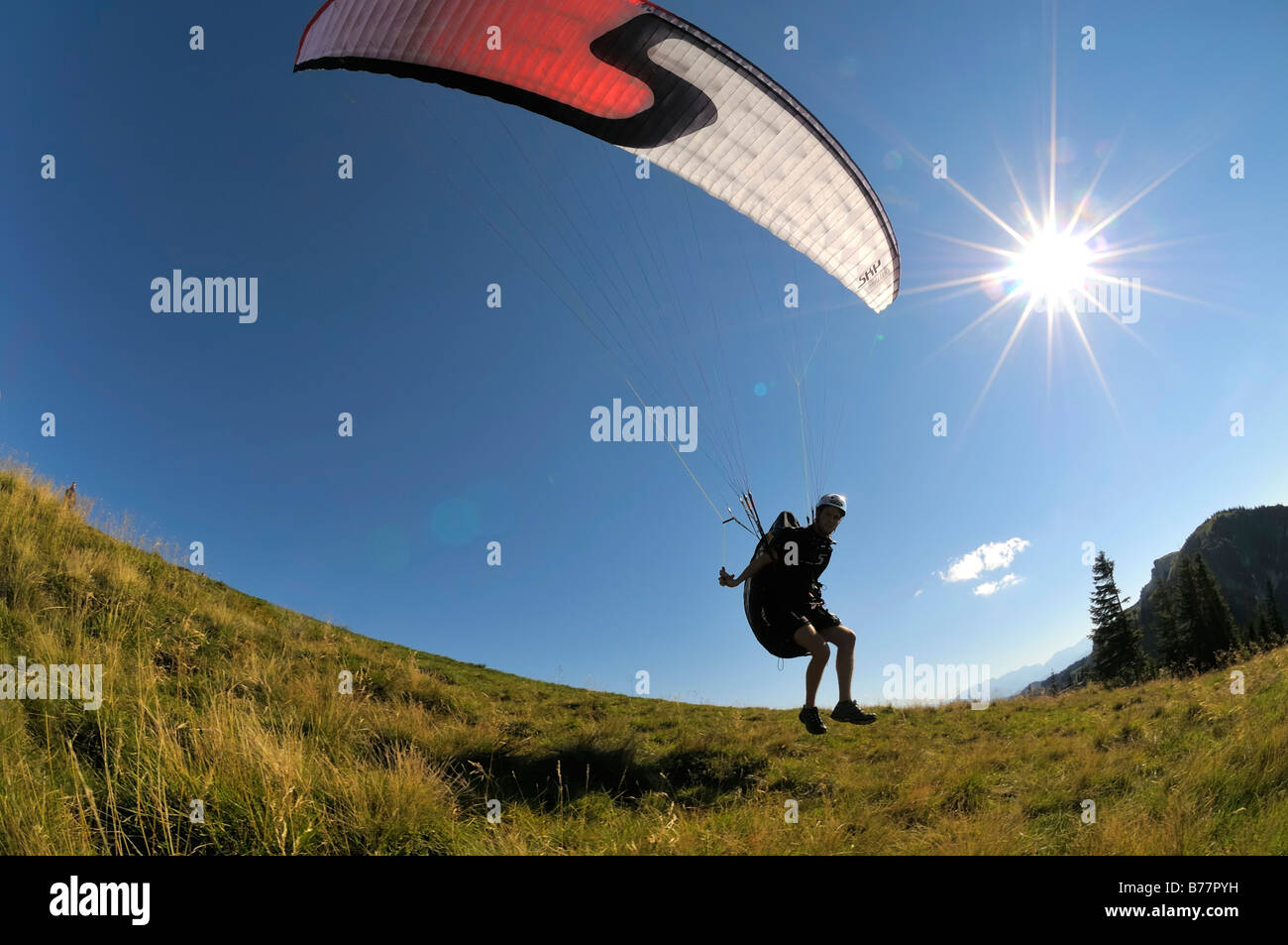 Parapendio decollo, retroilluminato, ampio angolo di ripresa, Brauneck, Alta Baviera, Germania, Europa Foto Stock