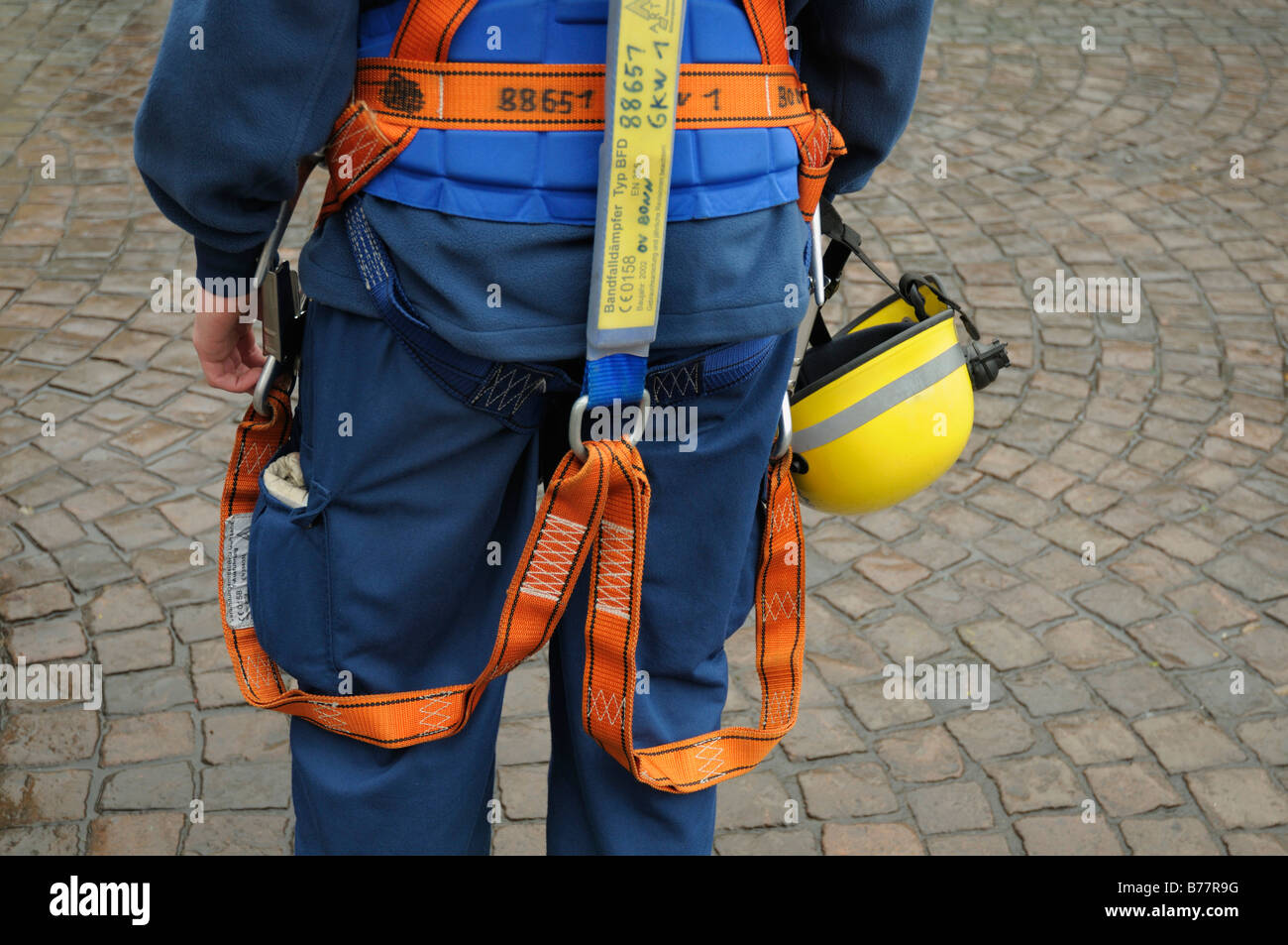 THW dipendente, vista posteriore, vista parziale, che indossa una cintura di sicurezza e un casco sui suoi fianchi, Norme Europee Foto Stock