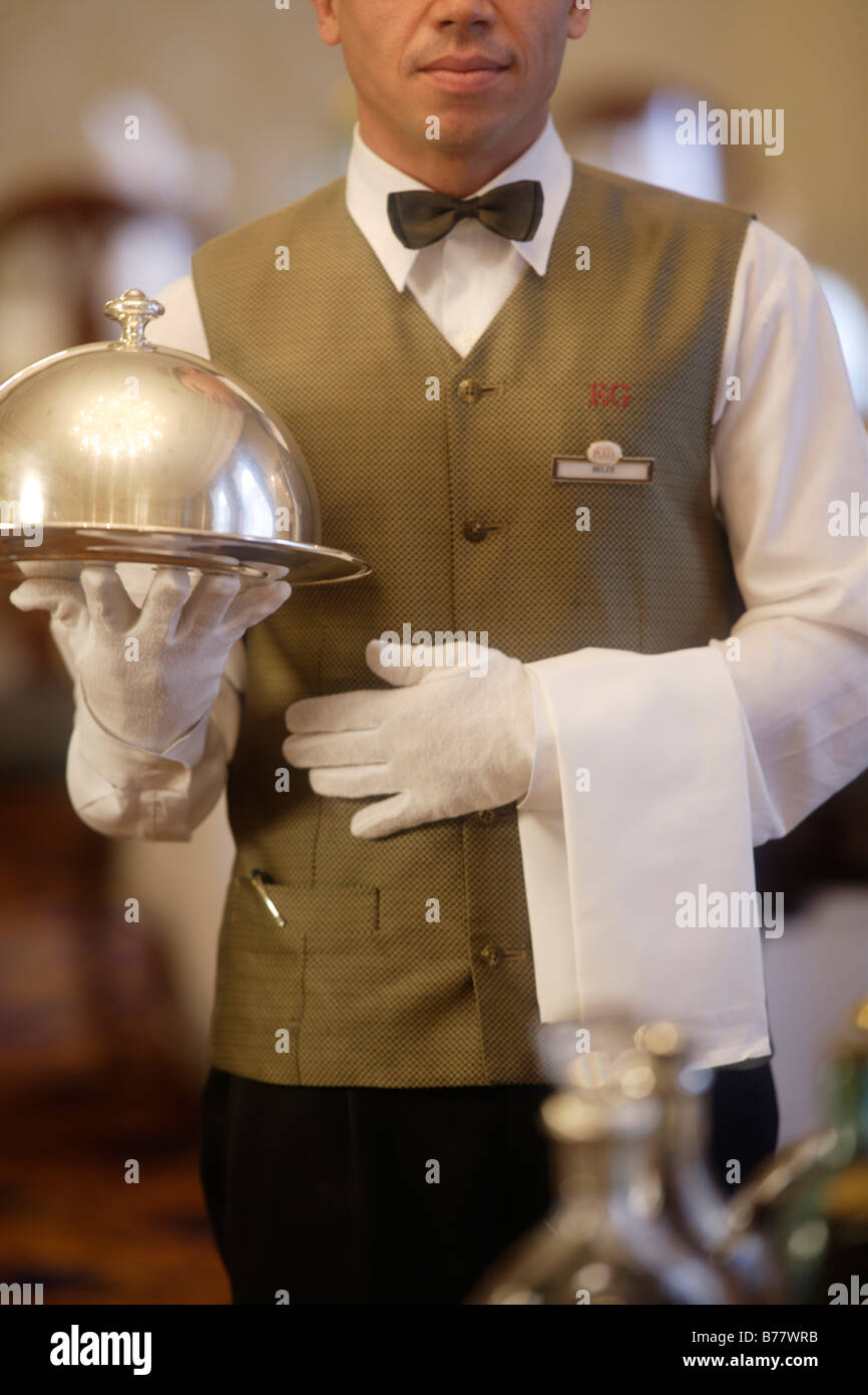 Cameriere in possesso di una cloche Foto Stock