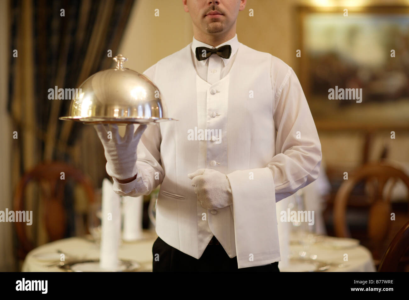 Cameriere in possesso di una cloche in un ristorante Foto Stock