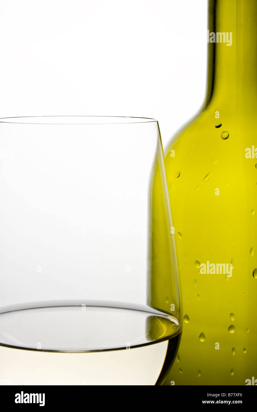 Primo piano della riempito di vino bianco e vetro verde bottiglia di vino. Retroilluminati. Una buona definizione dei bordi. Gocce di liquido in bottiglia Foto Stock