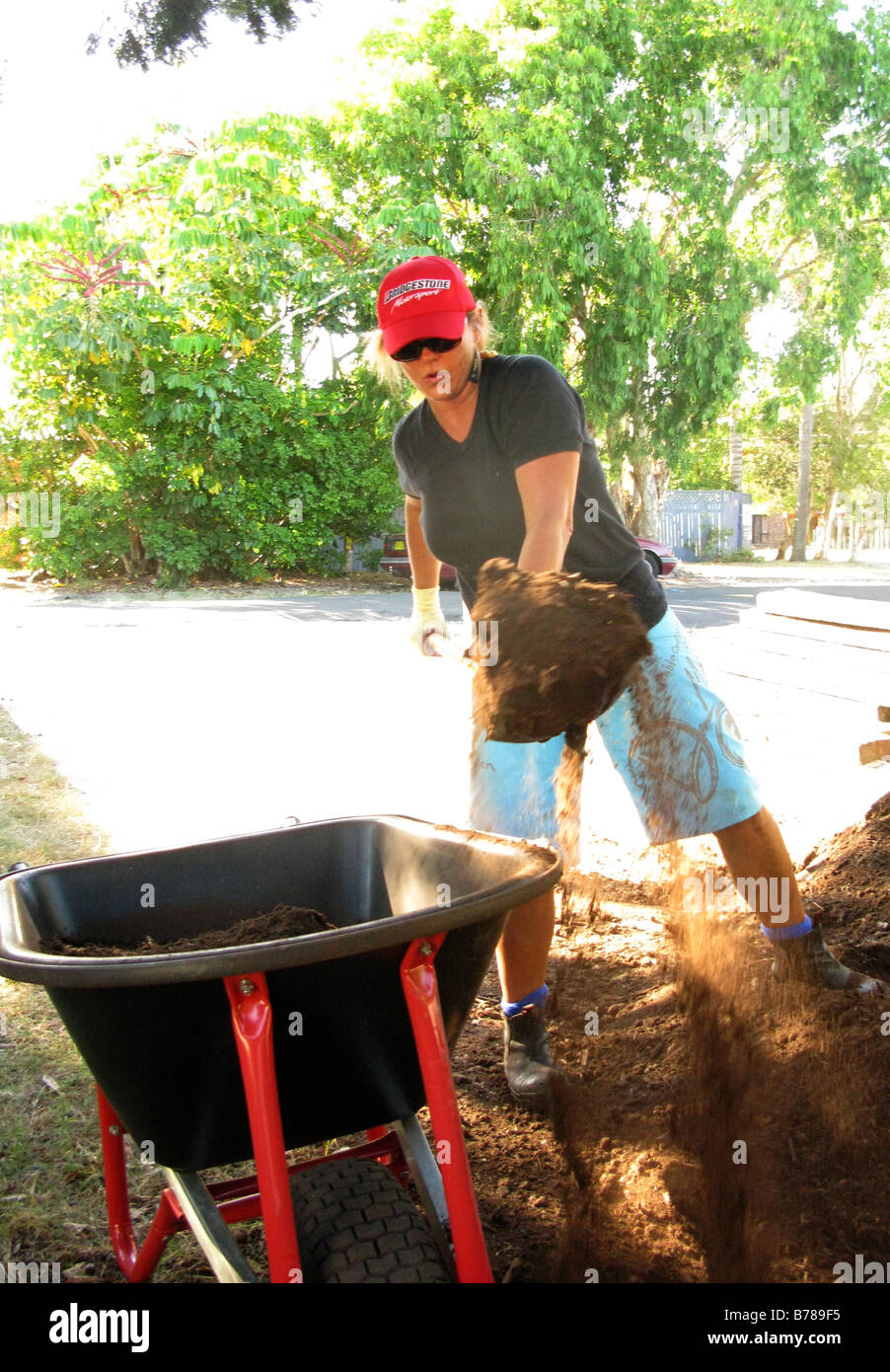 La donna lavora con pala e carriola Foto Stock