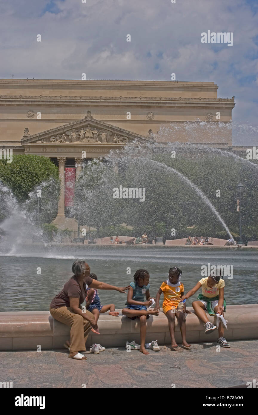 I bambini di riposo fontana sulla parete di fronte degli archivi nazionali, il Mall di Washington, DC turisti, studenti, nonna. Foto Stock