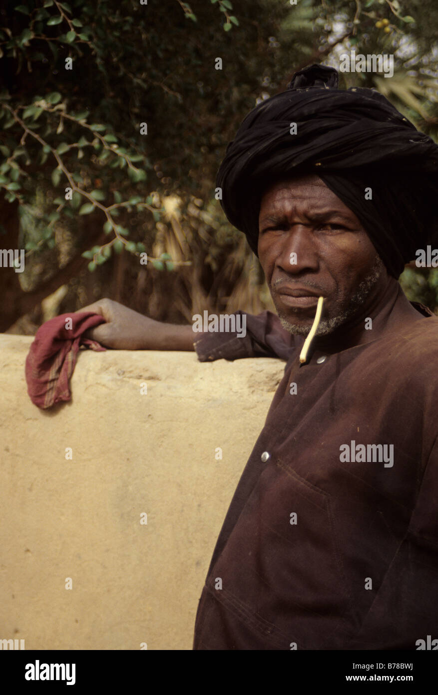 Vicino a Niamey, Niger. Fulani agricoltore usa un bastone da masticare per pulire i suoi denti. Foto Stock