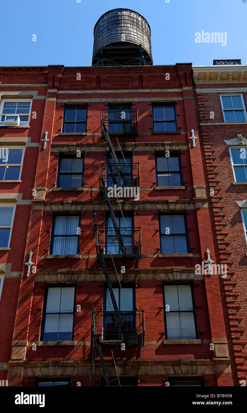 Casa residenziale con il fuoco e la scaletta in legno serbatoio acqua sul tetto, il Centro Cittadino di New York City, Stati Uniti d'America Foto Stock