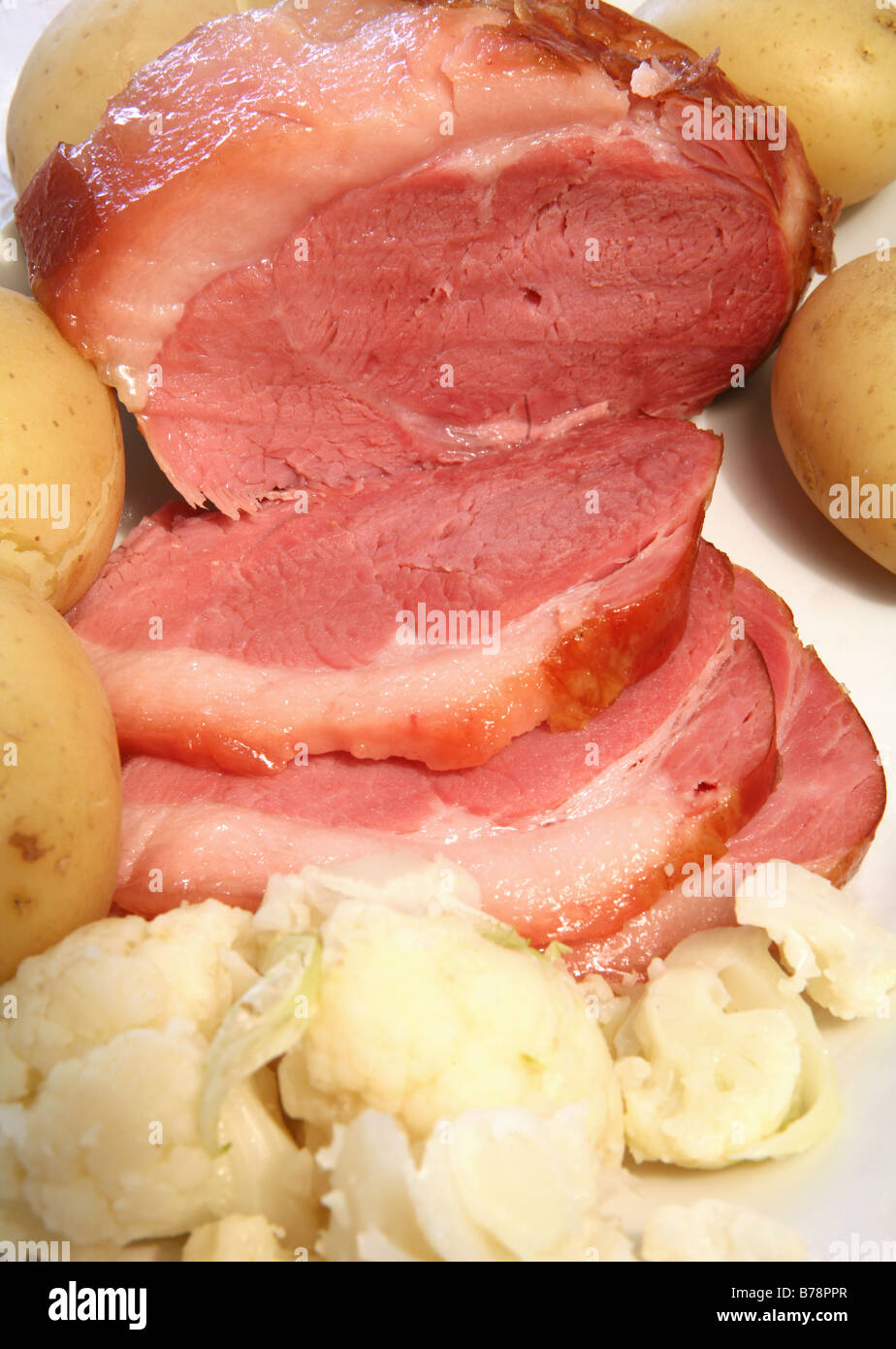 Un piatto di portata con una cotta gammon prosciutto,comune affettato,patate novelle bollite nel loro giacche e cavolfiore bollito Foto Stock