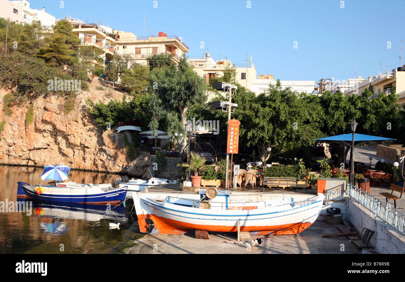 Una sorta di scivolo per imbarcazioni accanto ad una taverna a Aghios Nikolaos lago,Creta. Le piccole imbarcazioni da pesca sono ormeggiate ulteriormente indietro Foto Stock