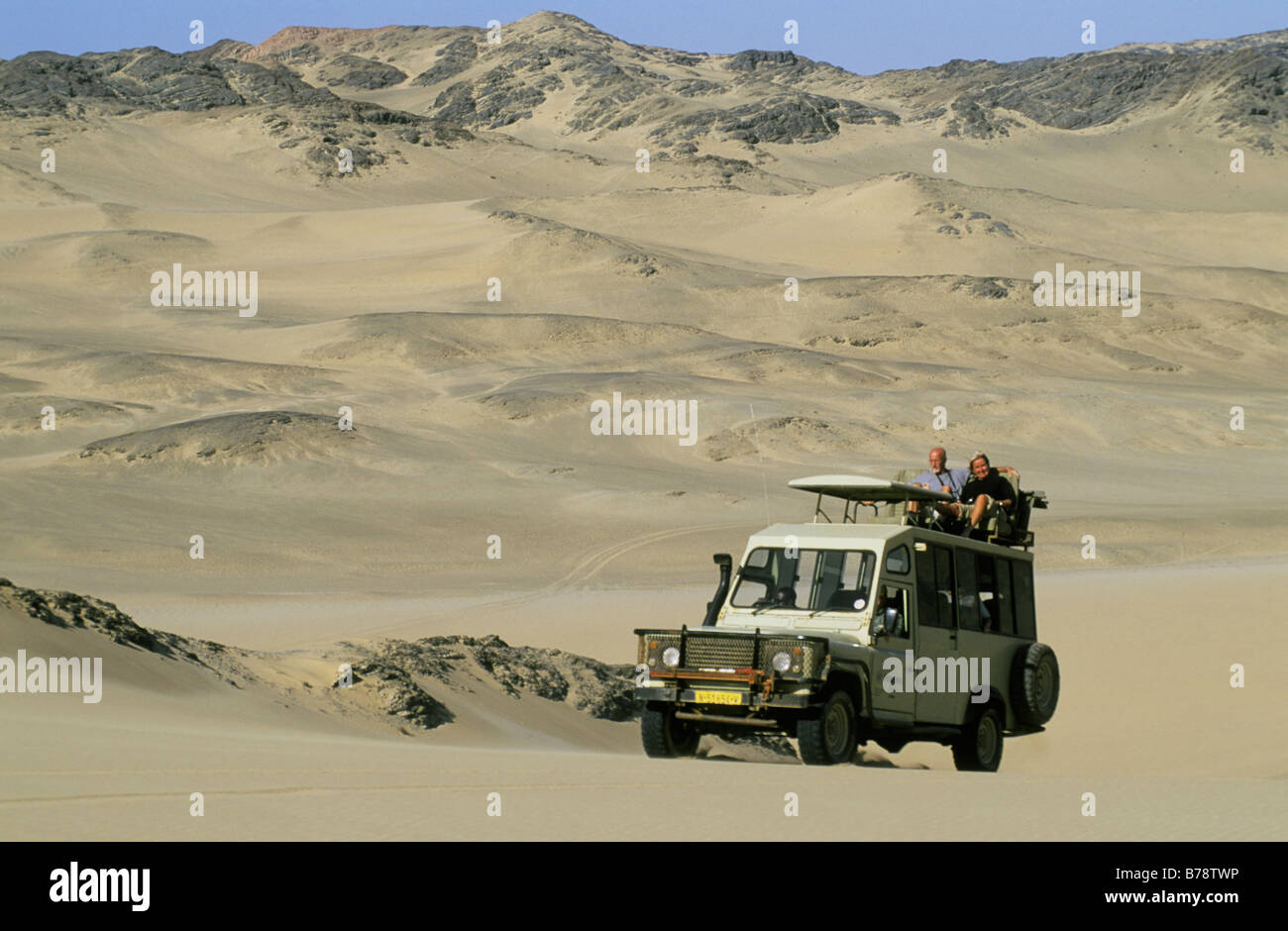 Un landrover con turisti guidando attraverso un deserto di montagna. Foto Stock