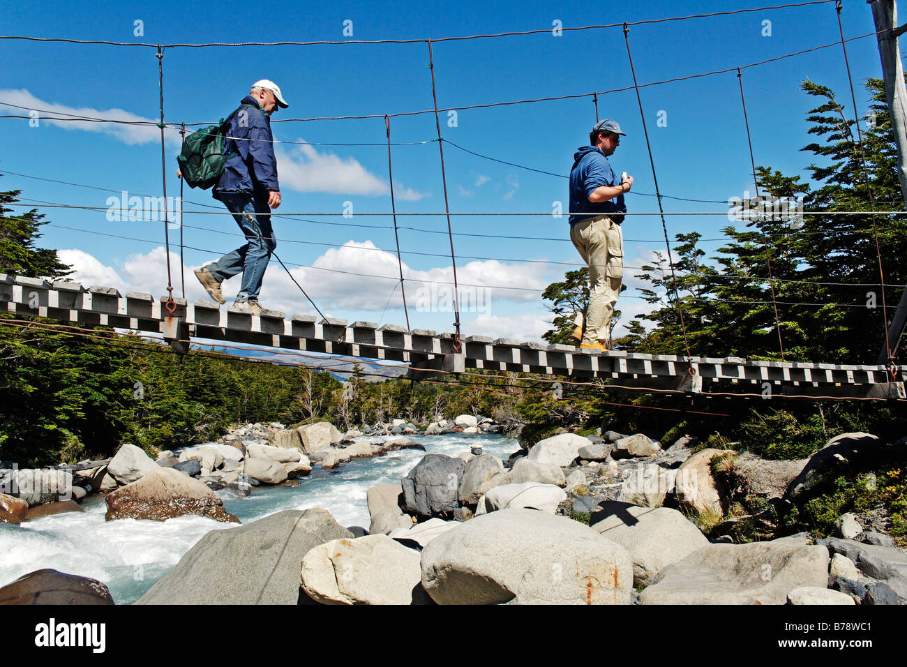 Gli escursionisti attraversando un ponte di sospensione nella Valle del Frances, Parco Nazionale Torres del Paine, Patagonia, Cile, Sud America Foto Stock