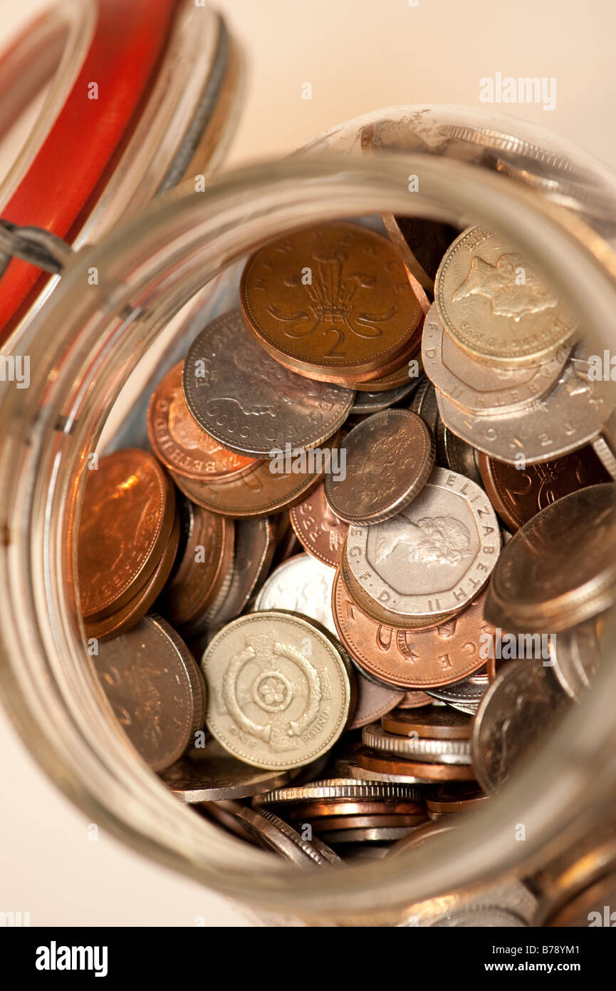 Vasetto di marmellata jamjar piena di monete del Regno Unito risparmio per un giorno di pioggia Foto Stock