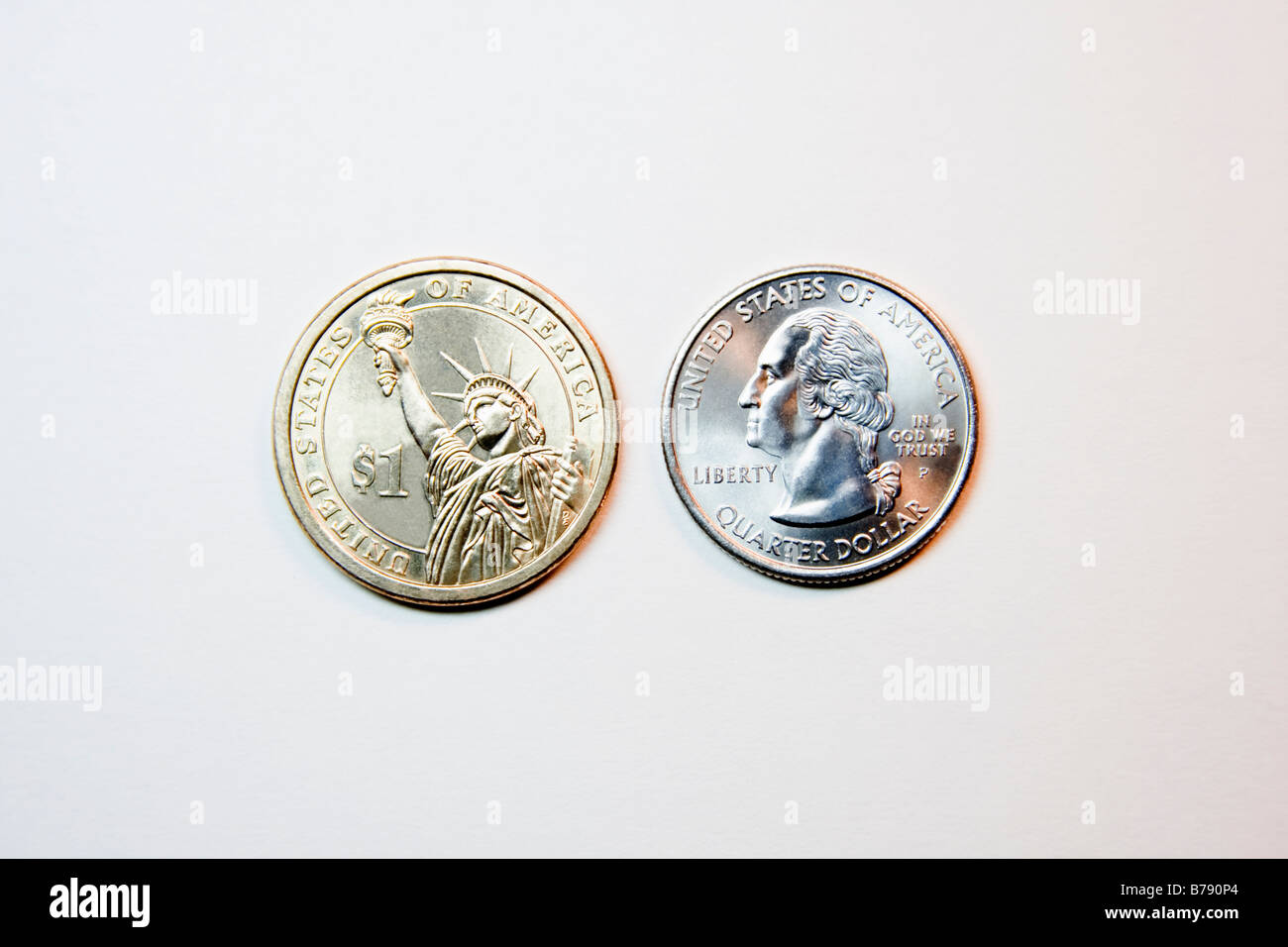 Valuta statunitense. Dollar Coin accanto a un quarto di confrontare le dimensioni. Foto Stock