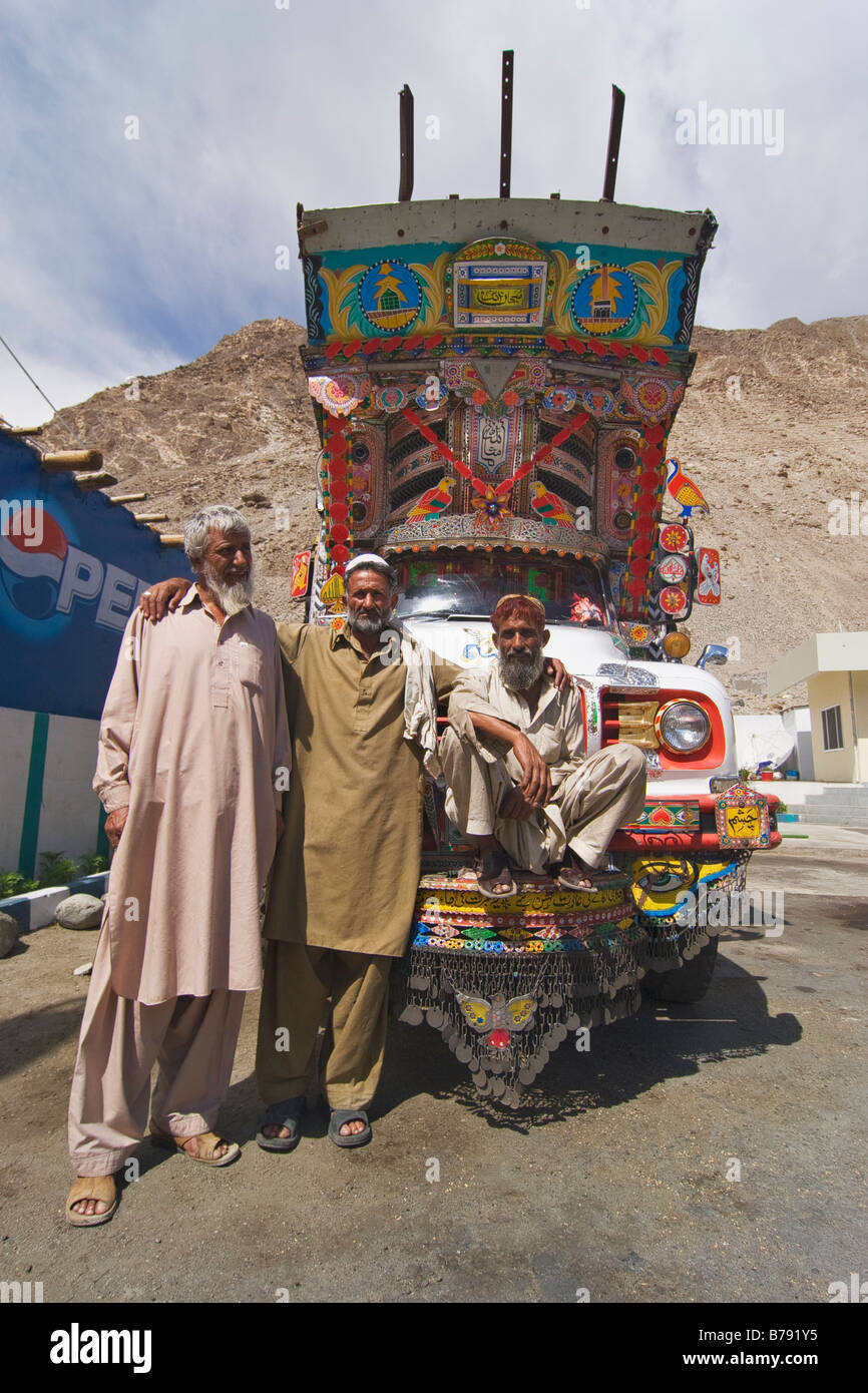 Tre Pakistani driver del carrello e un ornato trucke lungo la Karakoram Highway in Pakistan Foto Stock