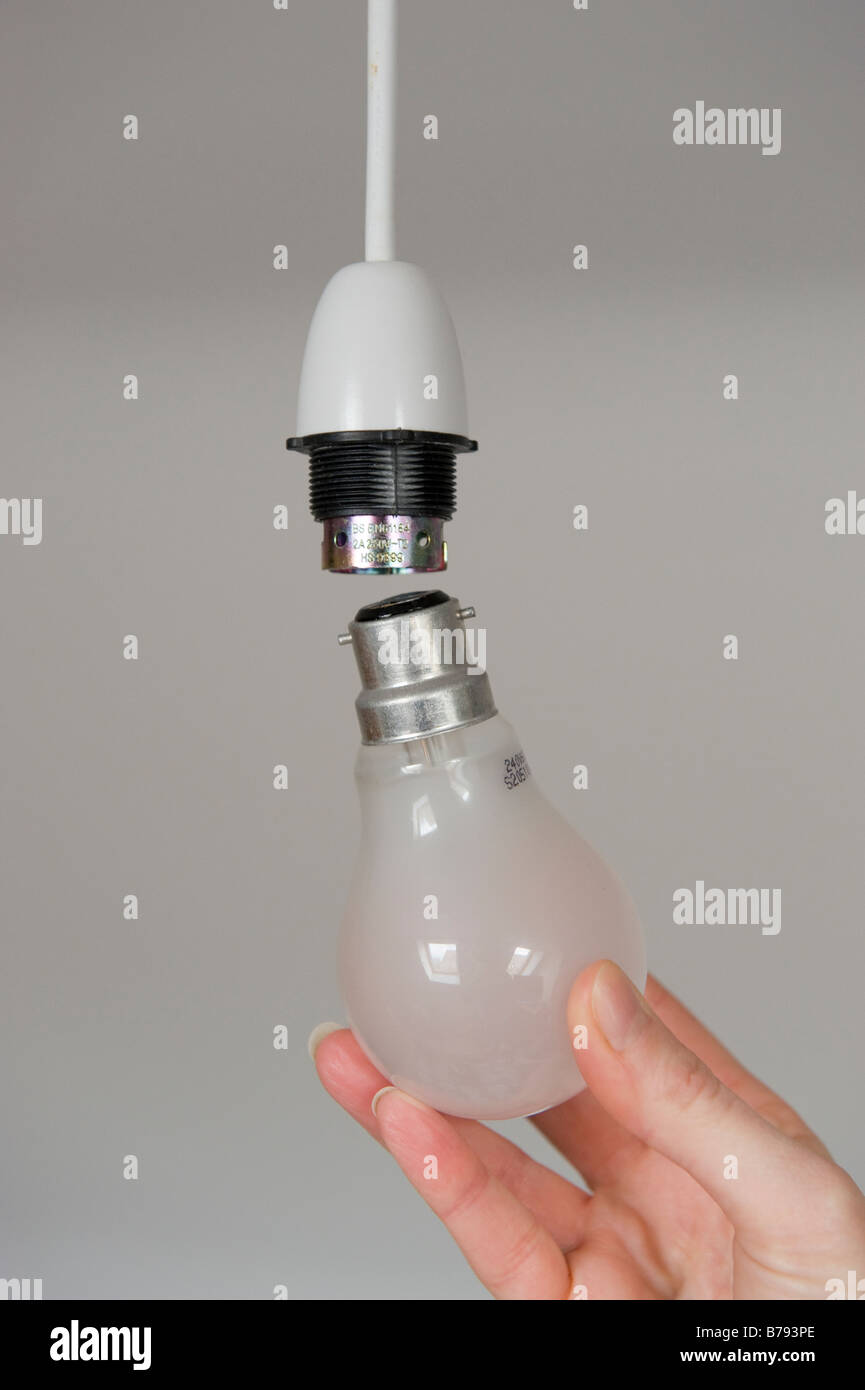 Un vecchio/lampadina tradizionale essendo collegato a un soffitto della presa della luce Foto Stock