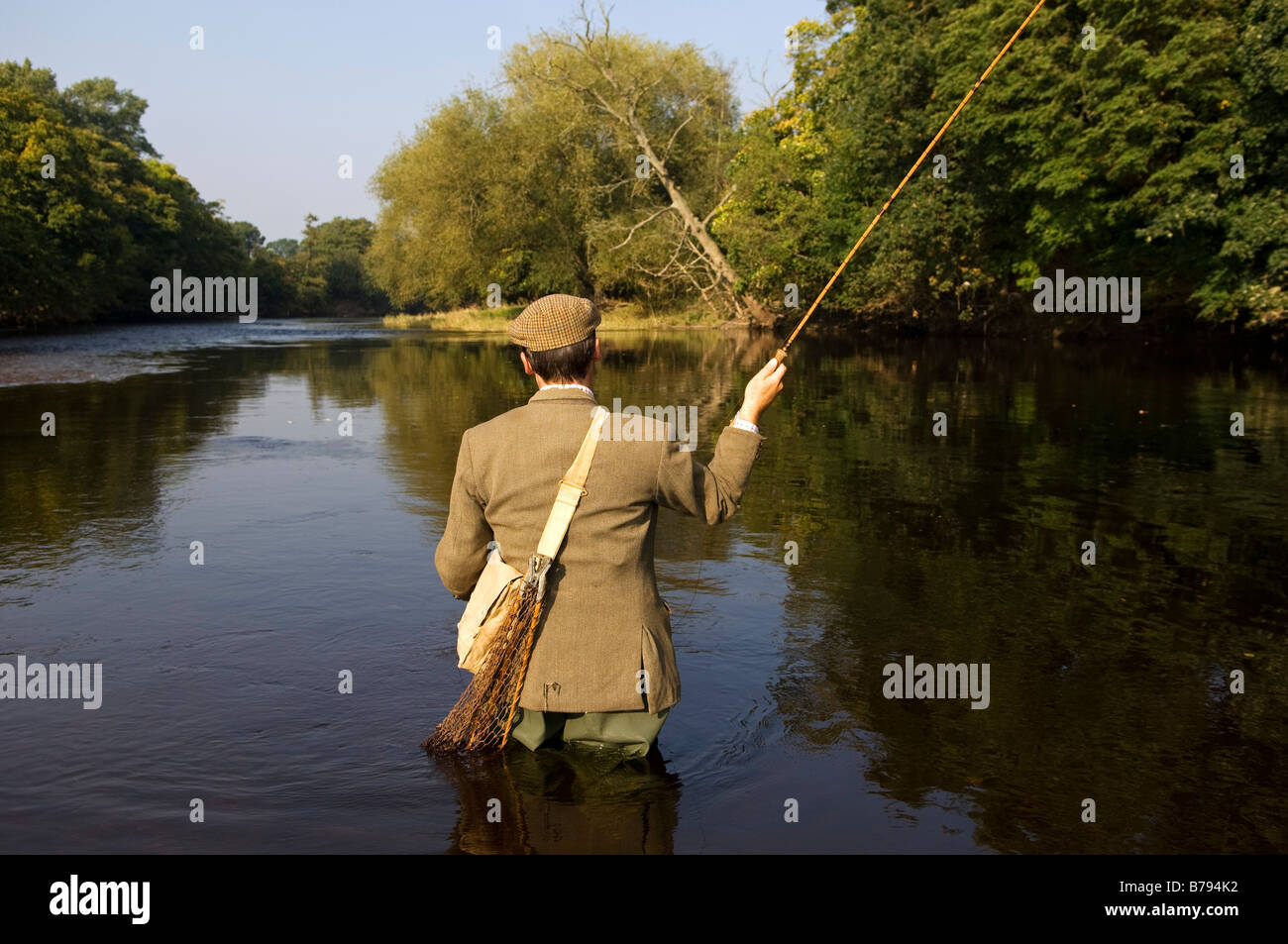 Il Galles, Wrexham. Un pescatore di trote fusione sul fiume Dee. (MR) Foto Stock