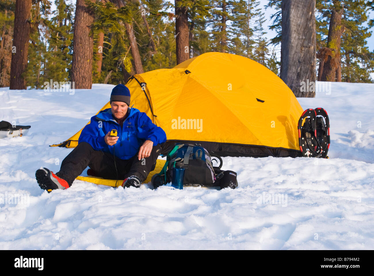 Backcountry rider utilizzando un GPS e calotta gialla tenda Yosemite National Park in California Foto Stock