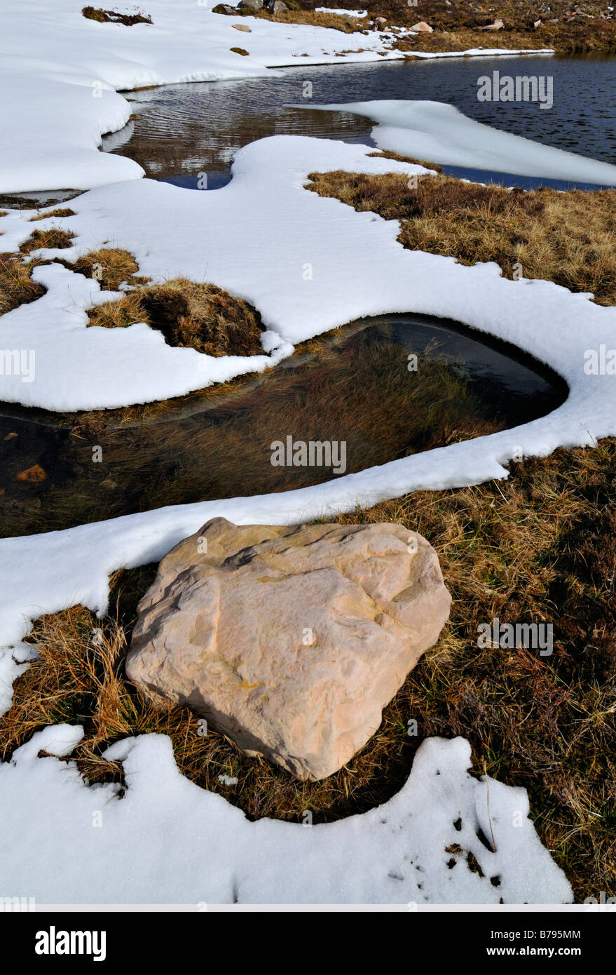 Modelli di snow rock erica e acqua durante la neve di primavera melt sulle alture di Applecross Inverness Shire w. Scozia Foto Stock
