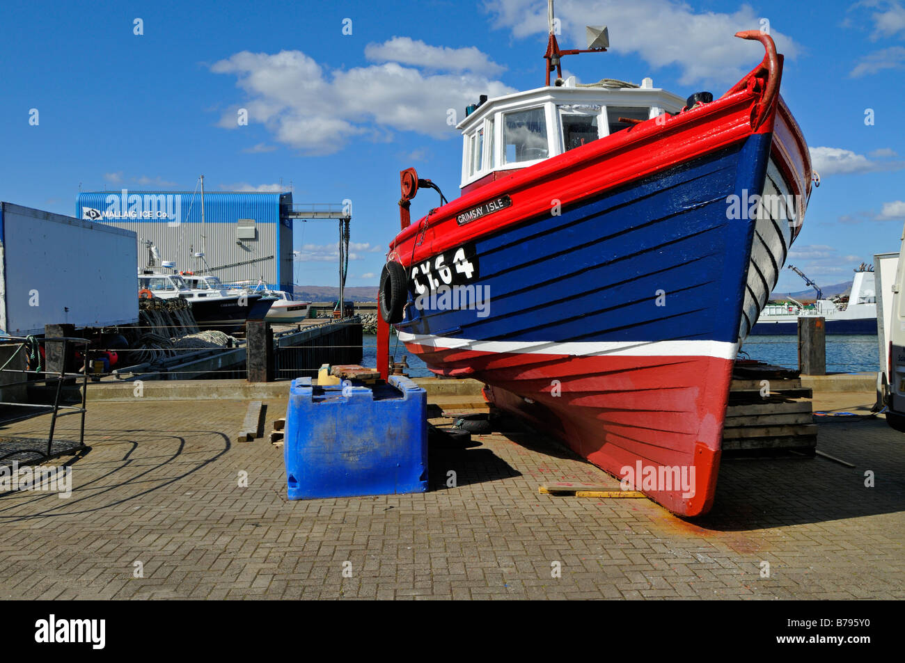 Luminose e recentemente dipinto di barca da pesca in cantiere di riparazione a Mallaig Inverness Shire Scotland Regno Unito Foto Stock