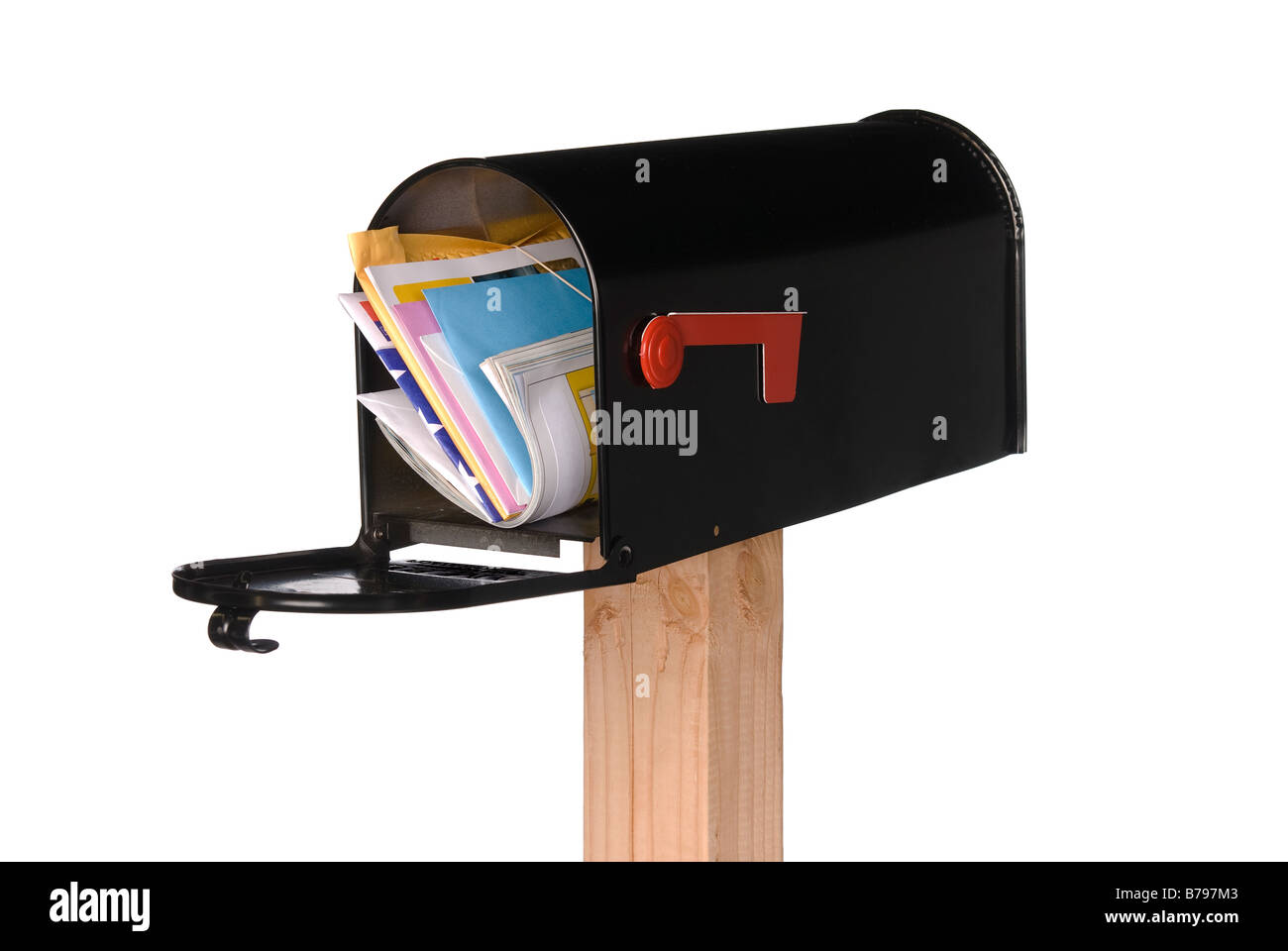 Un isolato nero mailbox riempito con lettere fatture biglietti di auguri e una rivista Foto Stock