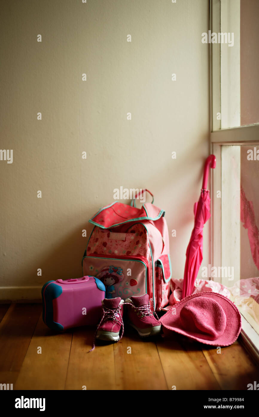 Bambina s rosa raccolta dal rivestimento della porta hat borsa ombrello stivali e lunchbox Foto Stock
