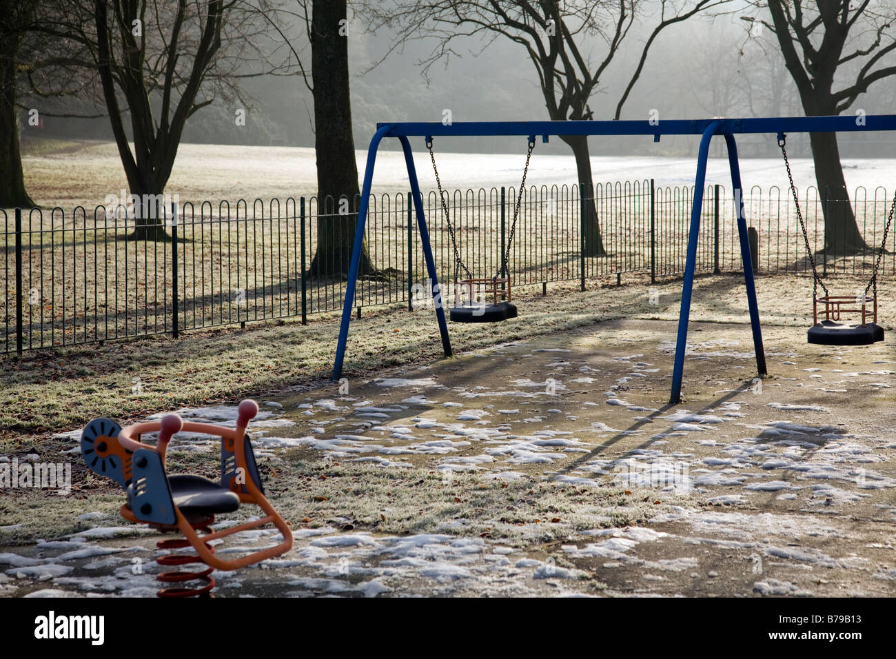 Parco giochi per bambini in inverno con neve sul terreno Foto Stock