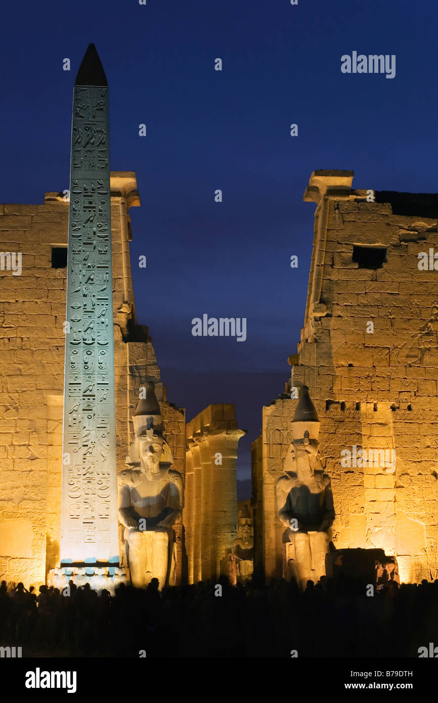 Tempio di Luxor Luxor Egitto. Primo pilone con obelisco e colossi di Ramesse II, crepuscolo Foto Stock