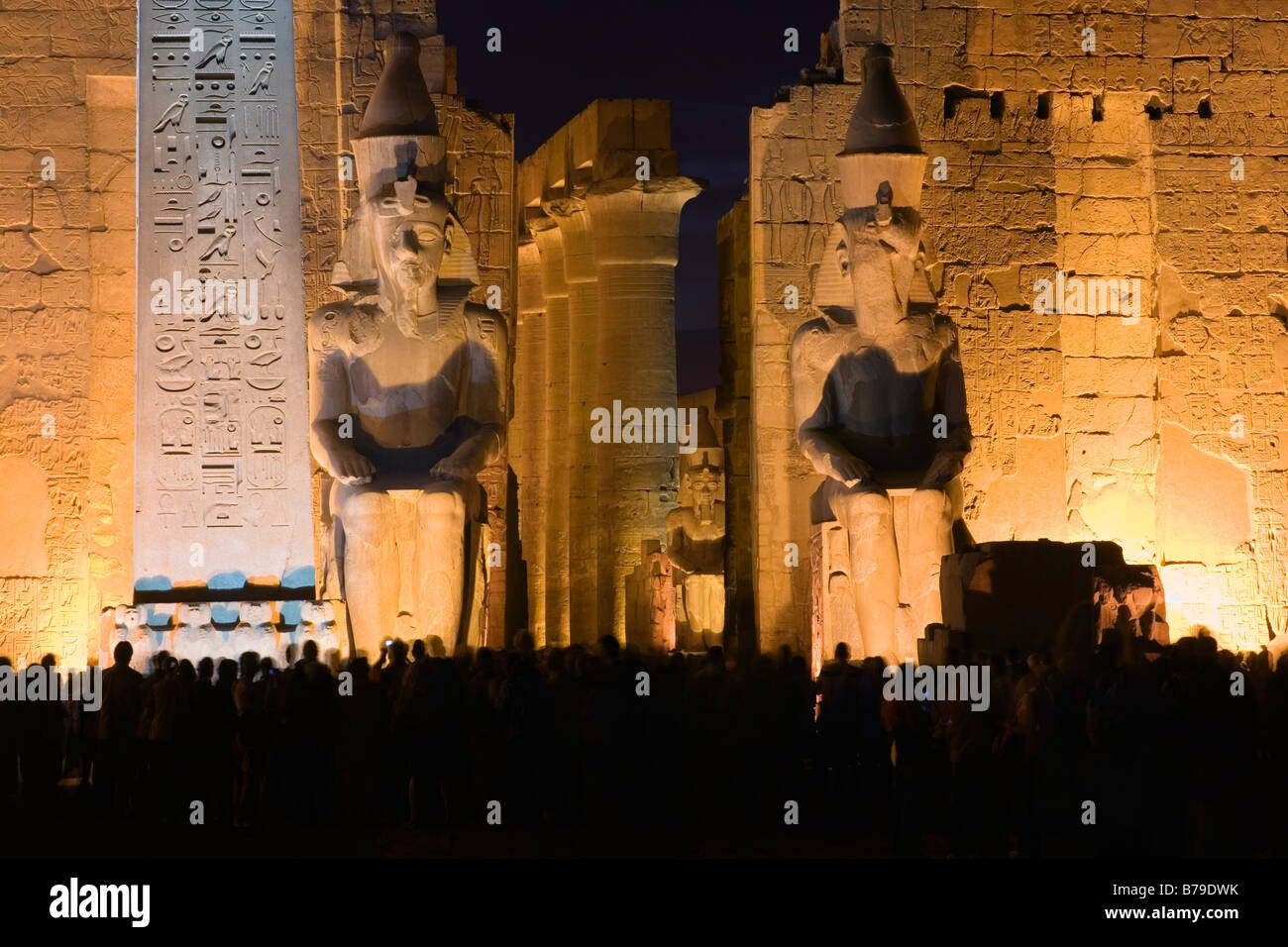 Tempio di Luxor, Egitto, Nord Africa. Colossi di Ramses II e obelisco, primo pilone, crepuscolo Foto Stock