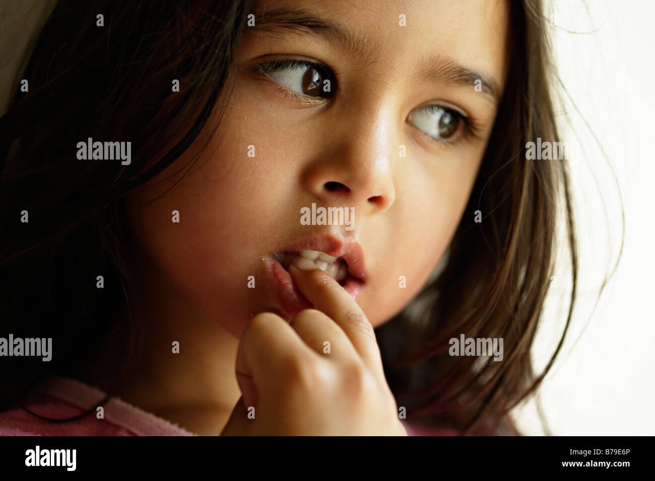 Bambina di cinque anni mastica unghie Foto Stock