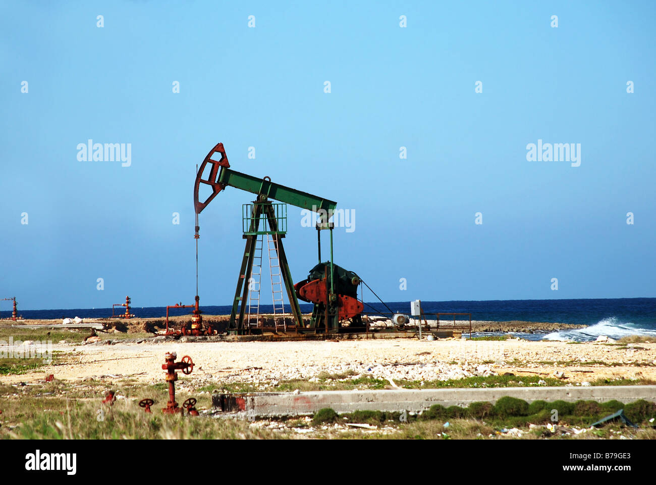 Pompa olio jack nel lavorare su un oceano o vedere la costa Foto Stock