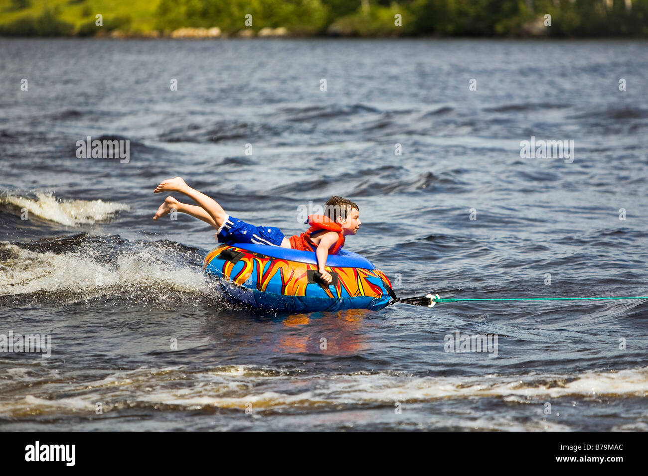 Ragazzo giovane tubing sul Lago di trote, Ontario, Canada Foto Stock