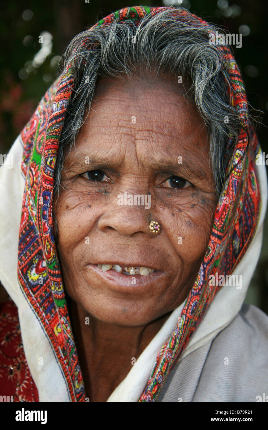 Un'anziana donna che indossa un colorato luminosamente velo al di fuori di casa sua nel villaggio di Mocha, Madhya Pradesh, India Foto Stock