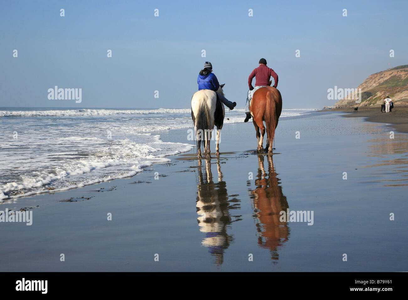 Giovane a cavallo sulla spiaggia con riflessioni, dorsi mostra, Equitazione lontano Foto Stock