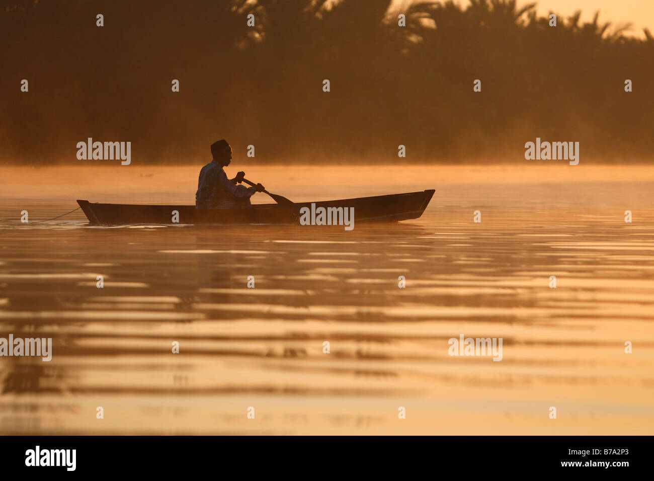 Pescatore, canoa, foschia mattutina, ramo di Sungai Barito Fiume nei pressi di Banjarmasin, Sud Kalimantan, Borneo, Indonesia, Sud- Foto Stock