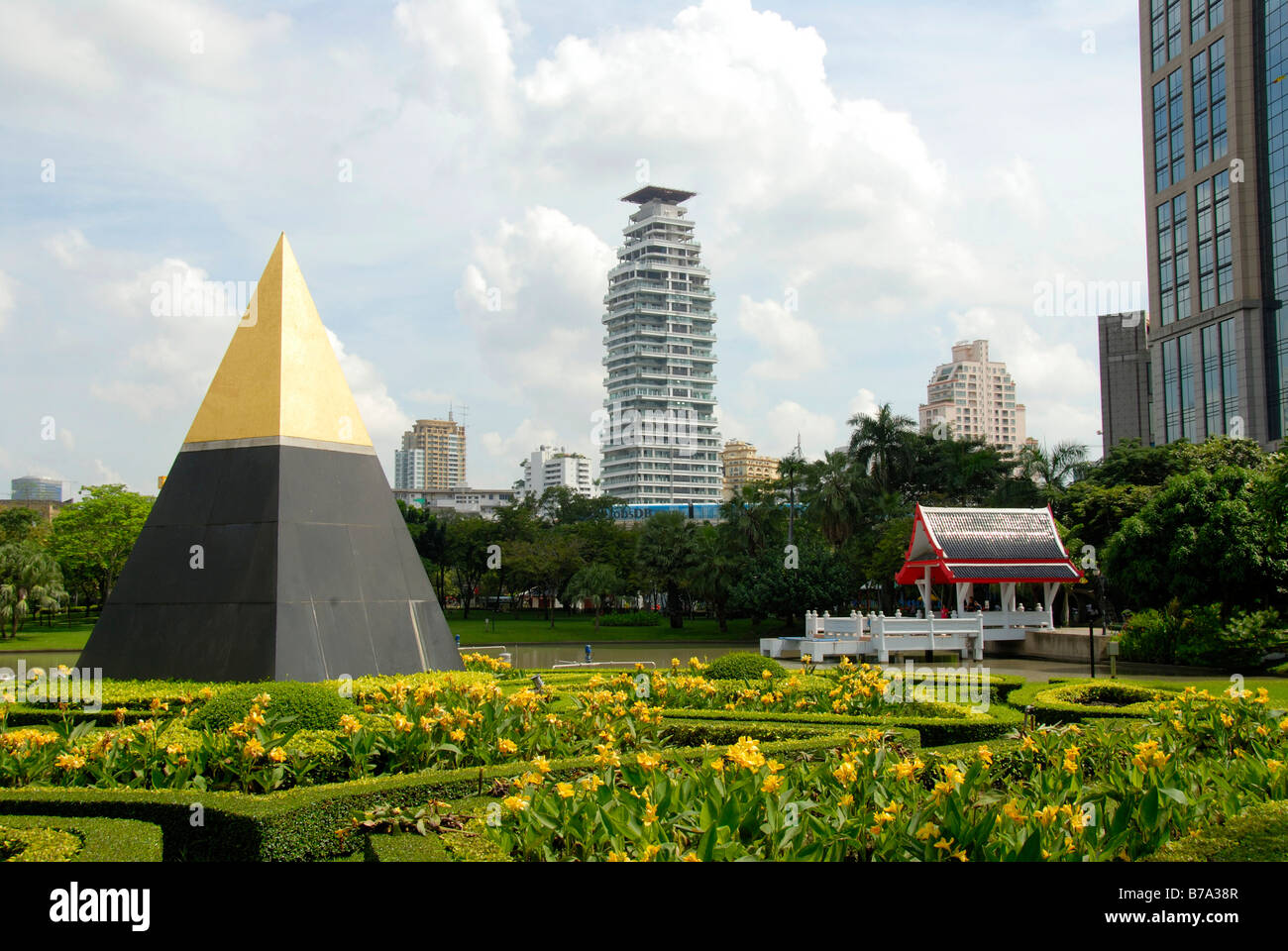 Piramide con un picco dorato nella parte anteriore di un tempio e moderni edifici multipiano, Queens Park, Bangkok, Thailandia, Sud-est asiatico Foto Stock