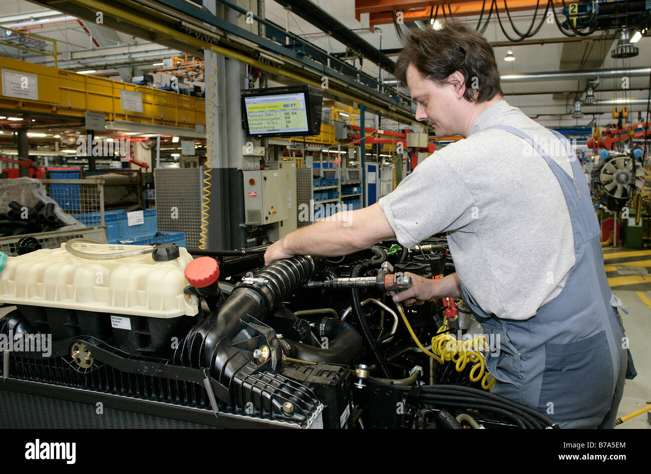 Operai a lavorare sul motore e la scatola del cambio di un camion, fabbricazione, produzione uomo Veicolo Commerciale Corporation, Monaco di Baviera, Bavar Foto Stock