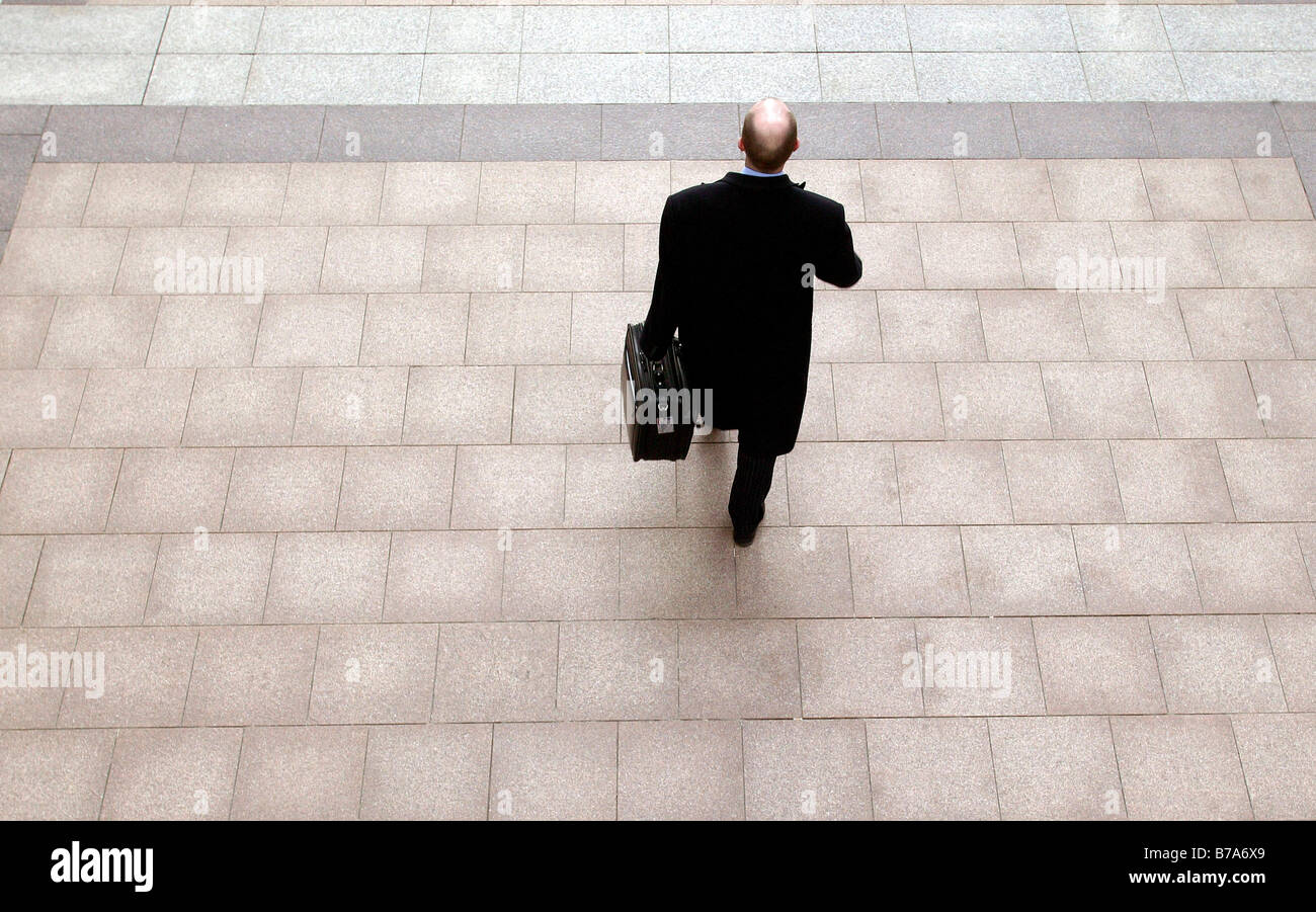 Imprenditore con una valigetta, passeggiate in Canary Wharf a Londra, Inghilterra, Gran Bretagna, Europa Foto Stock