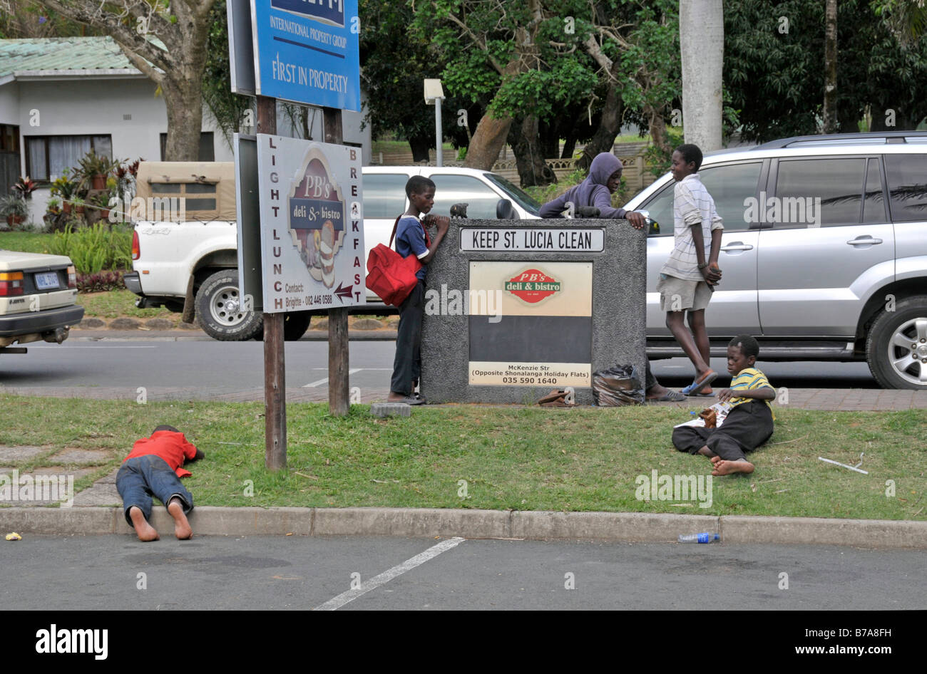Giovani operatori di strada di legno intagliato souvenir ai turisti, prendendo una pausa, Santa Lucia, Sud Africa e Africa Foto Stock