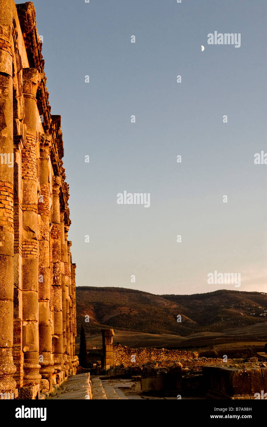 Rovine romane al tramonto con la luna in Volubilis, Moulay Idris, Marocco, Africa Foto Stock