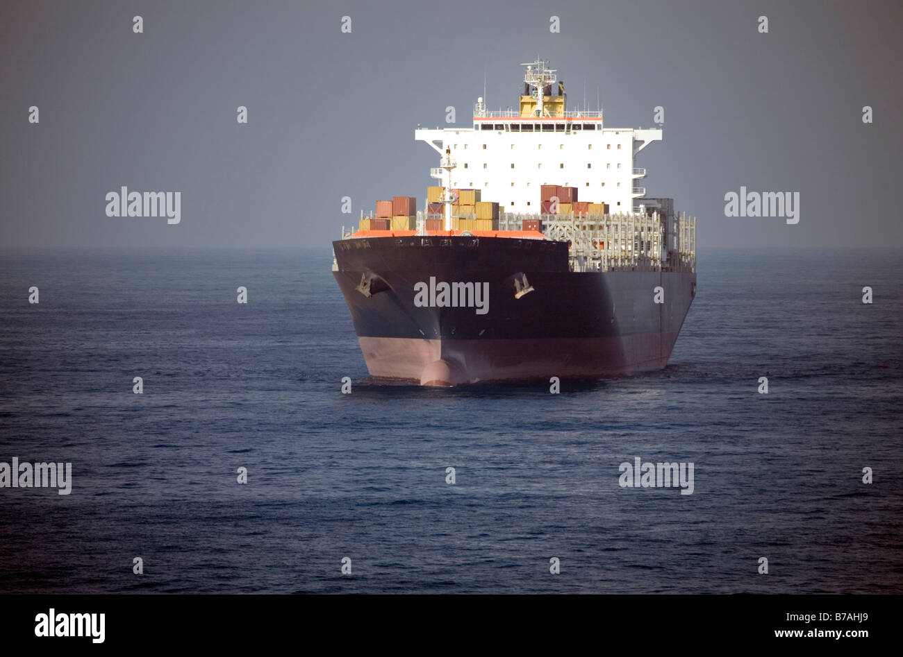 Nave da carico caricato con contenitori in mare entrando in porto senza identifyable loghi Foto Stock