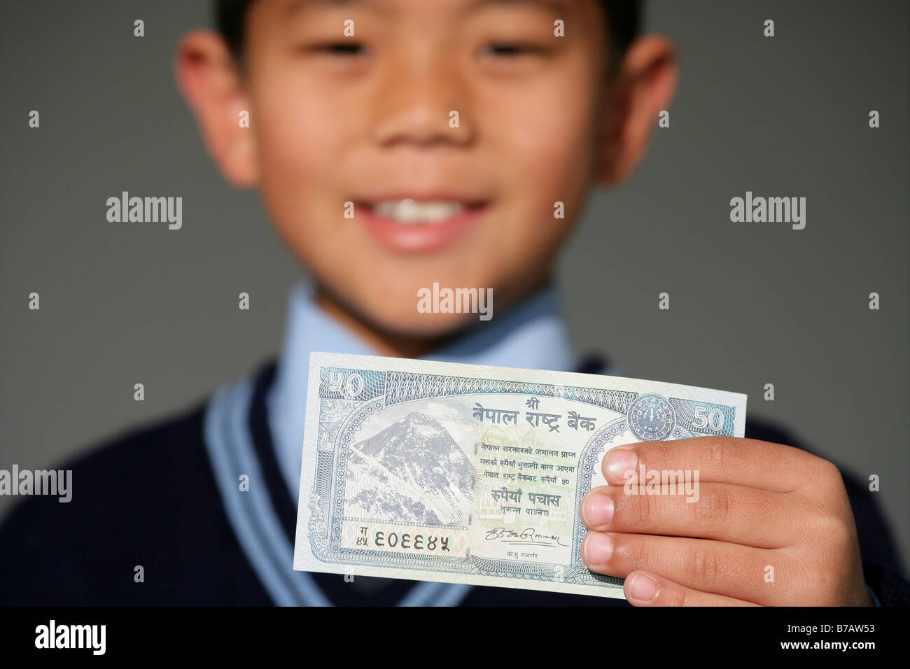 "Scuola Nepalese boys tenendo un cinquanta rupee nota" Foto Stock